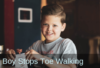 Boy smiling into Camera. Text: Boy stops toes walking