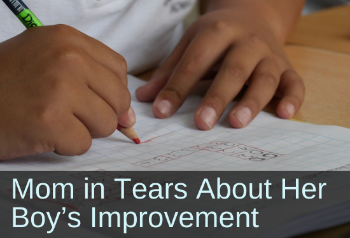 Close-up of a child's hands writing on paper. Text: Mom in tears about her boy's improvement.