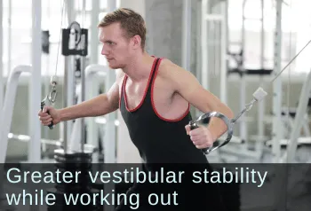 Young man using cable machine at gym. Text: Greater vestibular stability while working out