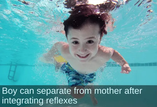 Smiling boy swimming underwater. Text: Boy can separate from mother after integrating reflexes.