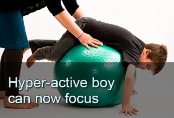 Boy on belly balancing on exercise ball. Text: Hyper-active boy can now focus.