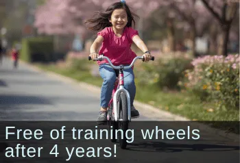 Young girl happily riding a bike. Text: Free of training wheels after 4 years!