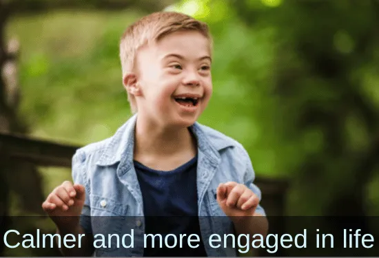 Little boy with Down's Syndrom laughing. Text: Calmer and more engaged in life.
