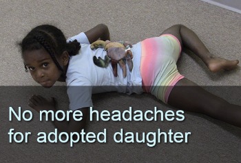 Young girl doing exercises on belly. Text: No more headaches for adopted daughter. Links to a case study titled, "No More Headaches for Adopted Daughter"