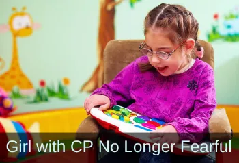 Girl working with learning toy on a laptray. Text: Girl with CP no longer fearful.