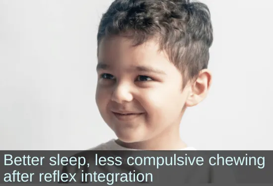 Smiling boy looking off-camera. Text: Better sleep, less compulsive chewing after reflex integration.