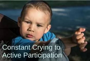 Young boy looking into camera. Text: Constant crying to active participation.