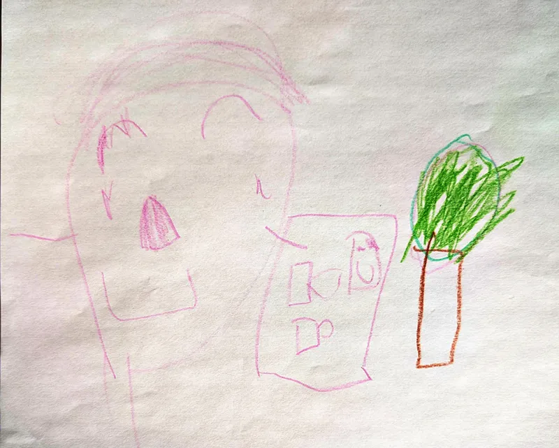 Light crayon strokes showing a large person -- just a head with features. In the middle is a smaller rectagle with squares representing windows. To the right of that is a tree with a rectangular trunk and a scribbled circle above respresenting a bushy collection of leaves.