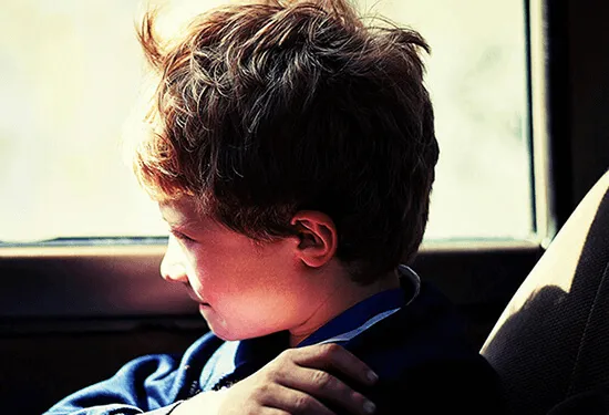 Pensive boy looking out a window